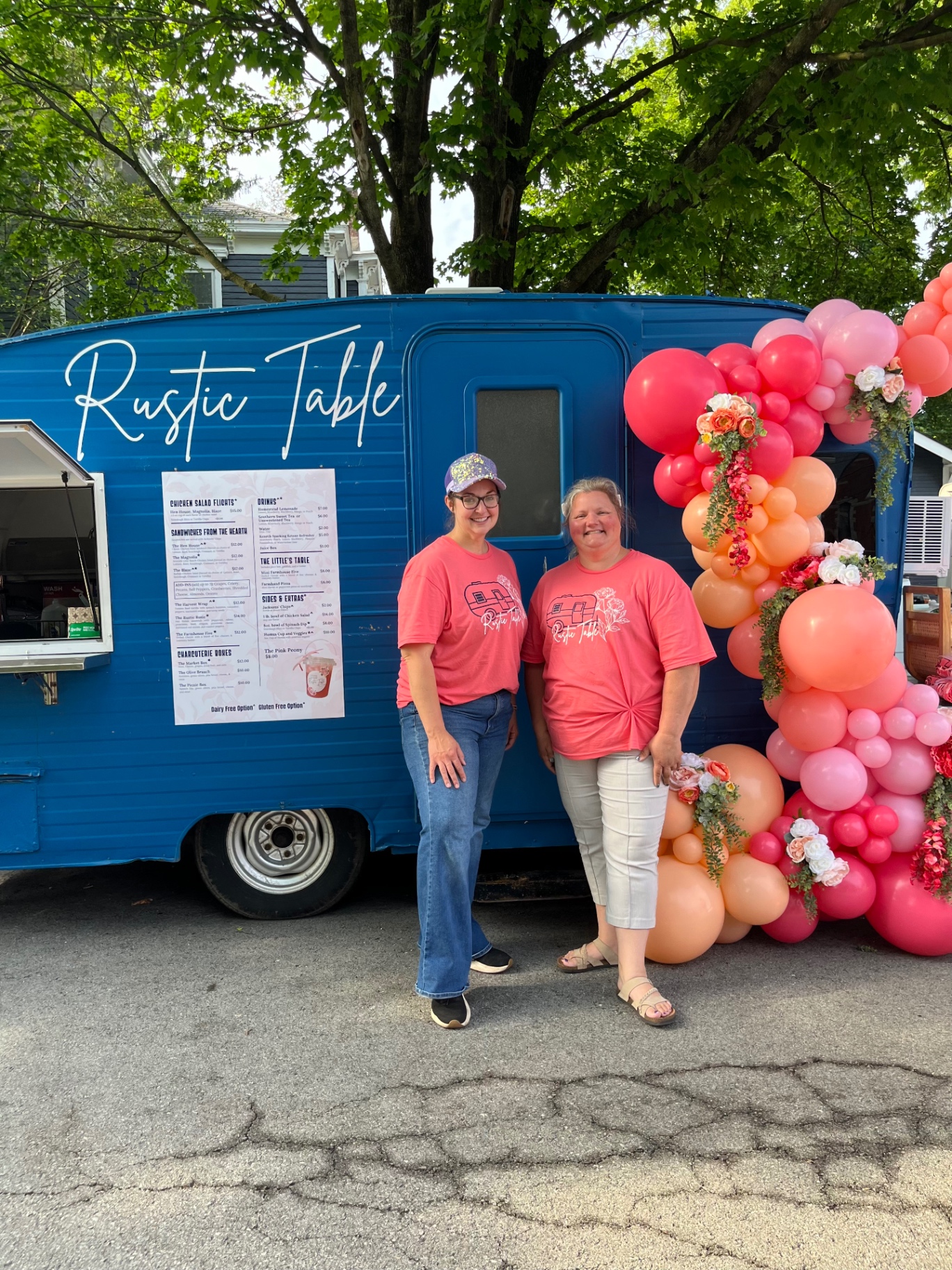 Jessica and Dana standing in front of the Rustic Table camper
