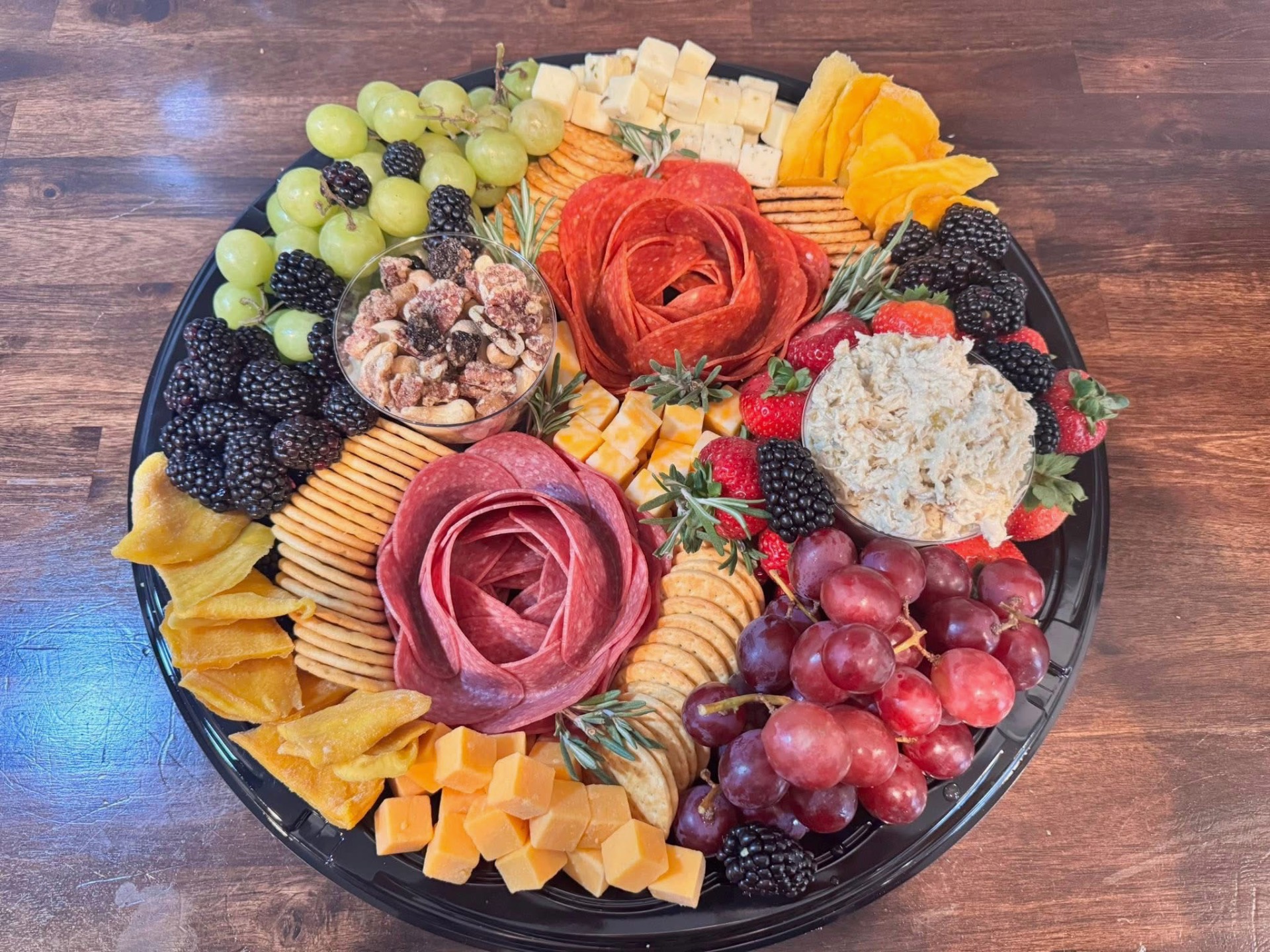 Charcuterie platter with meats, cheeses, fruits, and nuts